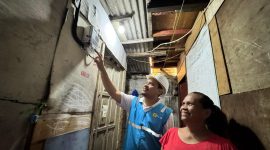 Umi (kanan), salah satu warga Jalan Rela, Kelurahan Menteng Atas, Kecamatan Setia Budi, Jakarta Selatan tampak bahagia dengan kehadiran listrik yang disambung oleh petugas PLN.